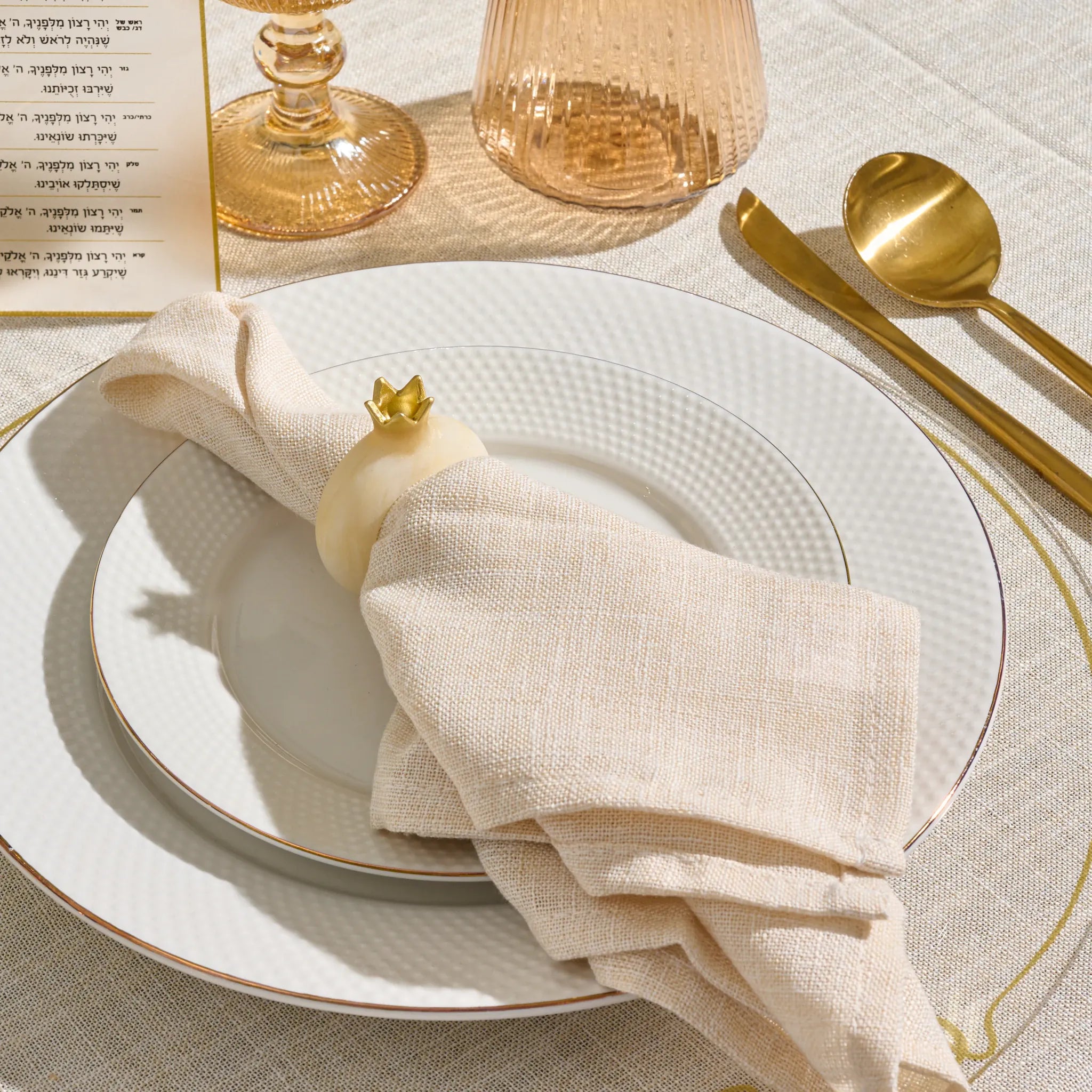 Gold resin pomegranate napkin ring on a folded napkin for Yom Tov