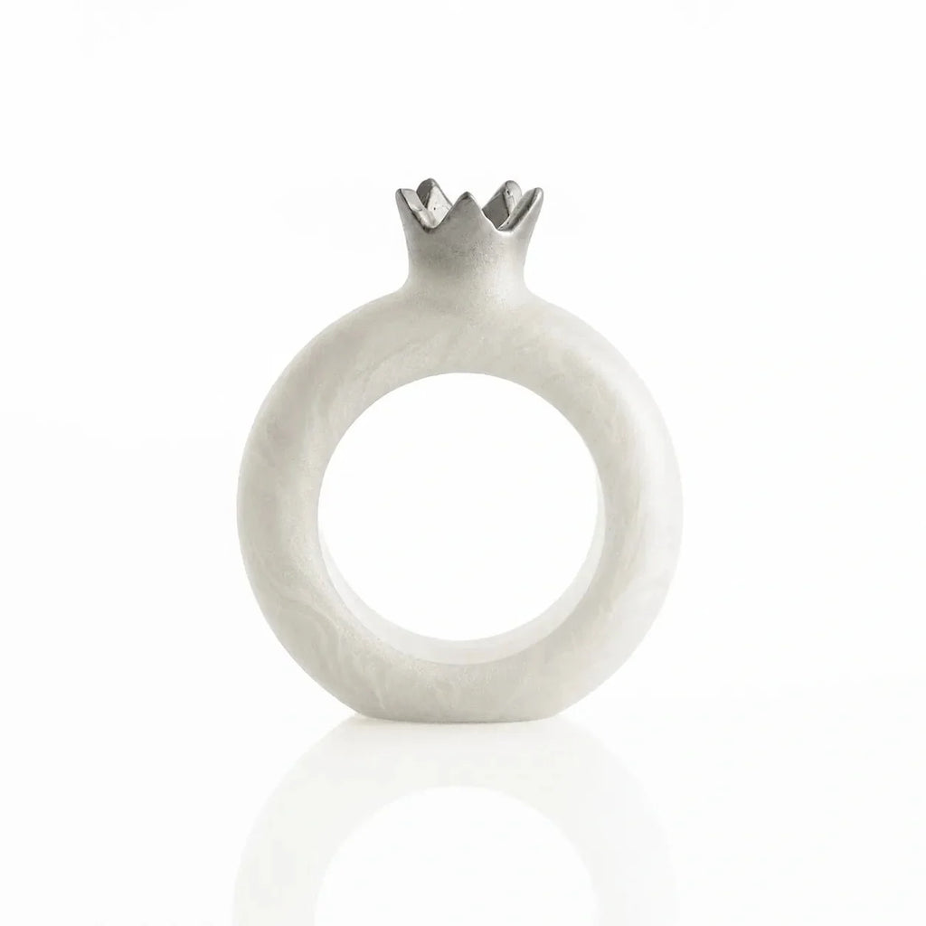 Silver resin pomegranate napkin rings framing napkins at each seat