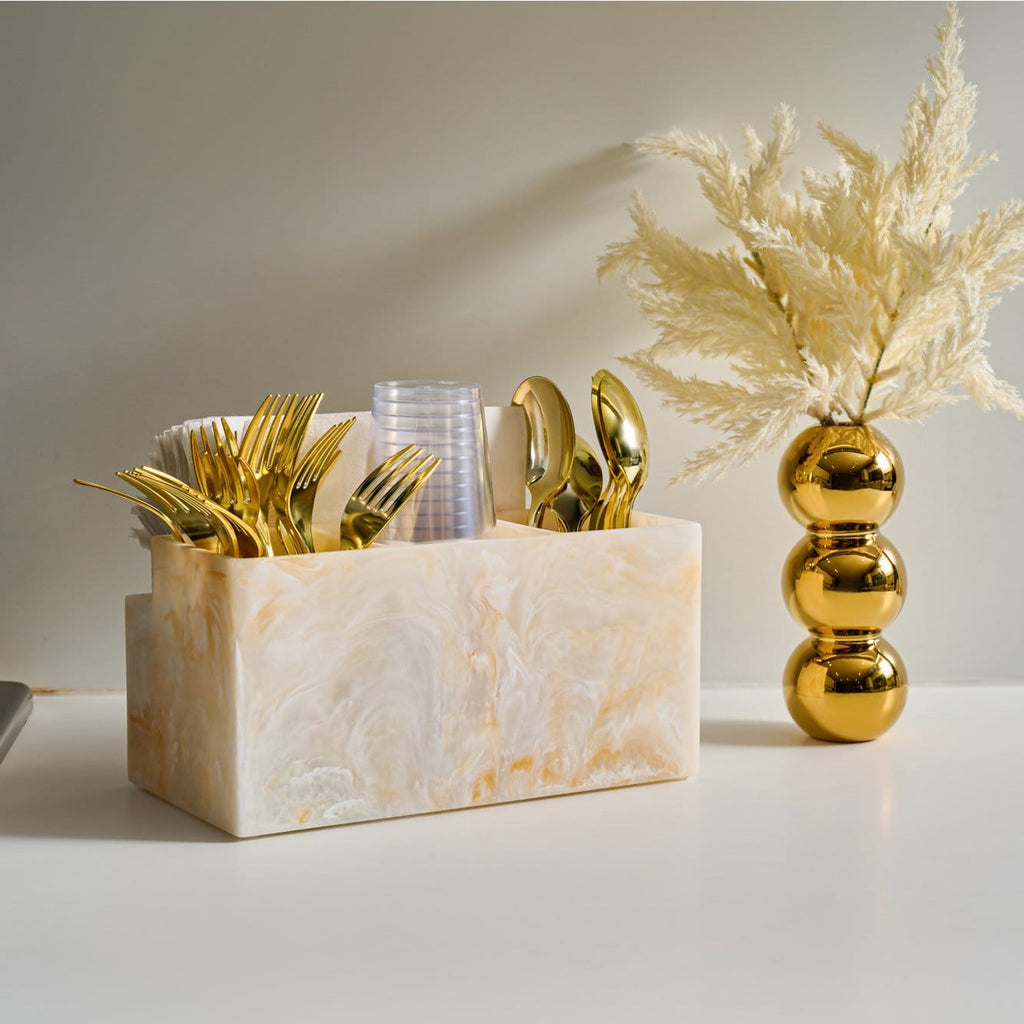Resin silverware caddy with a marble-look finish, organized tabletop holder for cutlery and napkins.