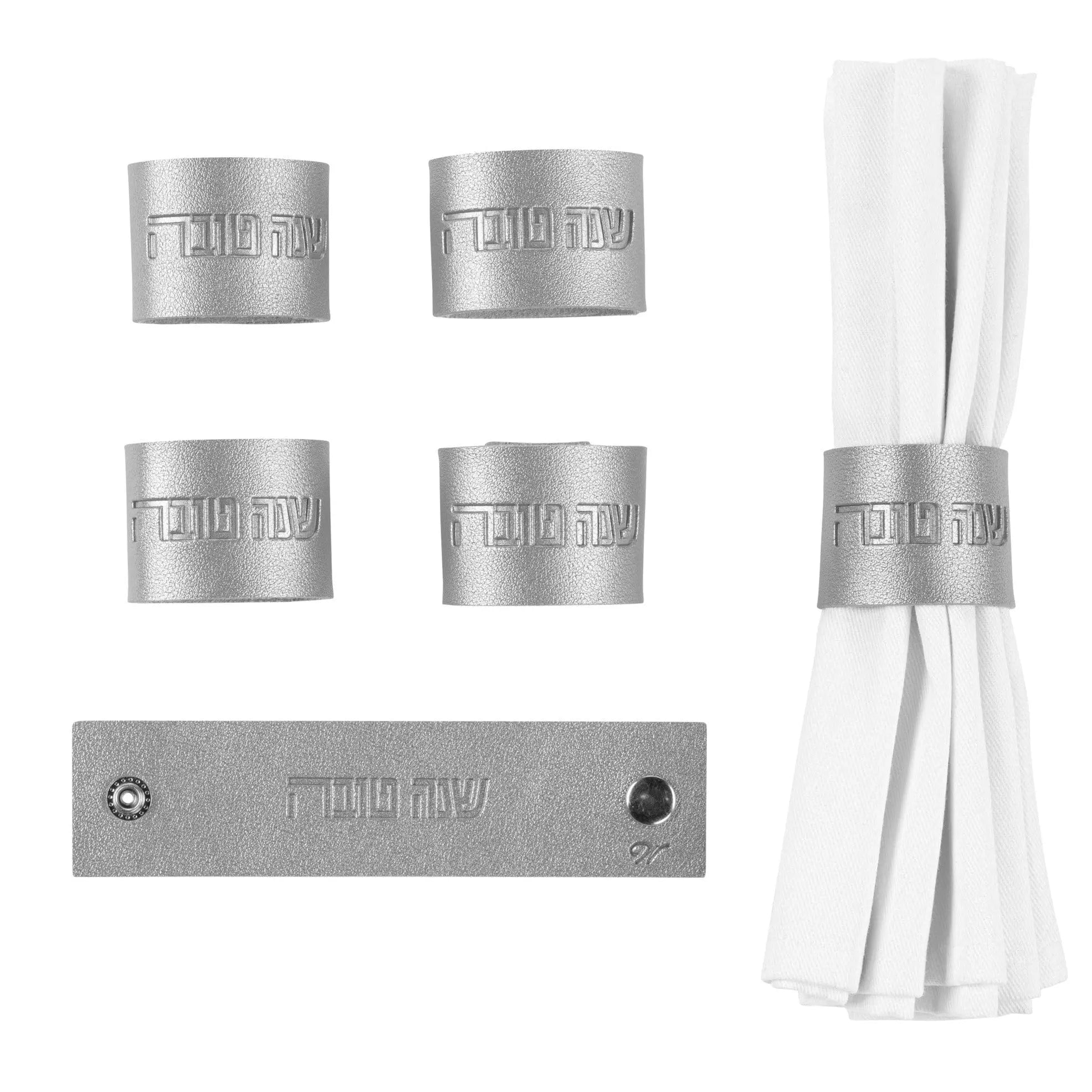 Silver leatherette napkin wraps from Waterdale Collection, shown with matching napkin rings in a product display set for holiday table settings.