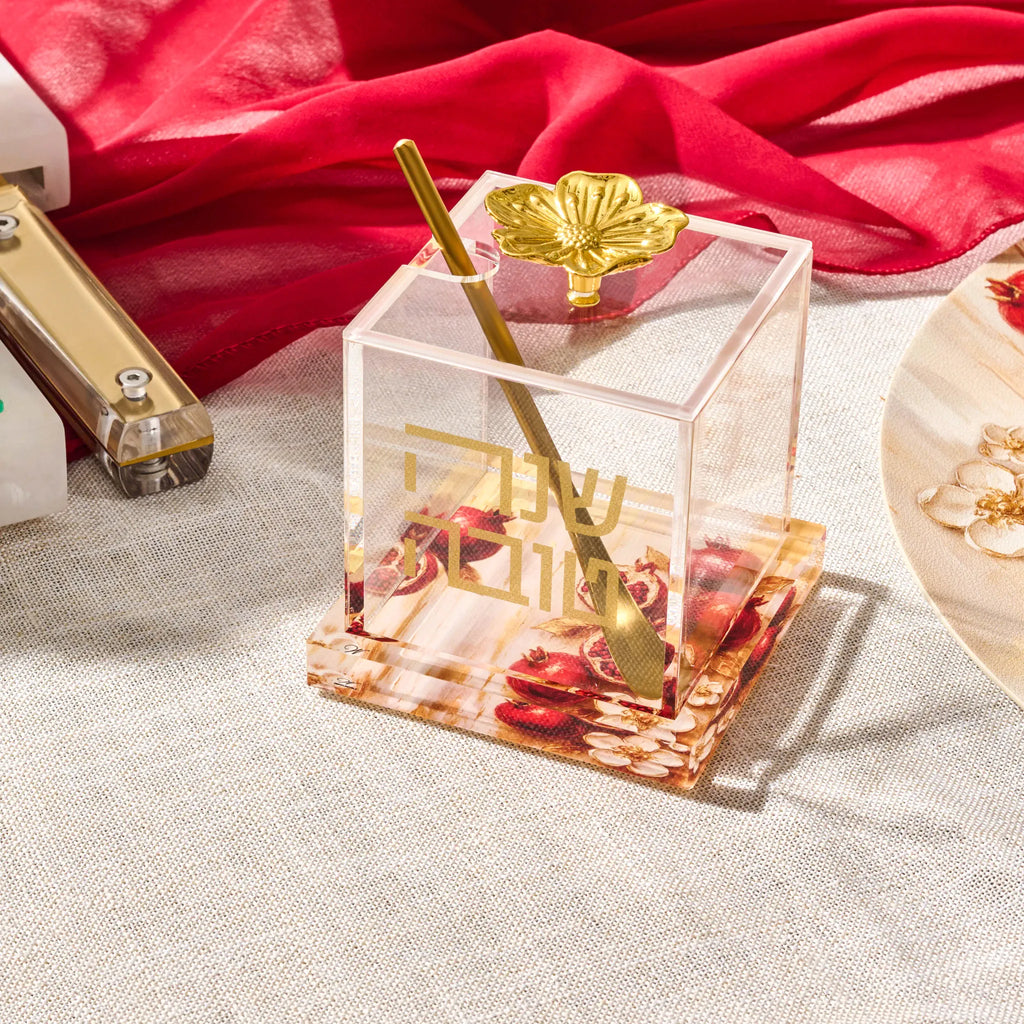 Painted pomegranate honey dish with a matching gold spoon for Rosh Hashana
