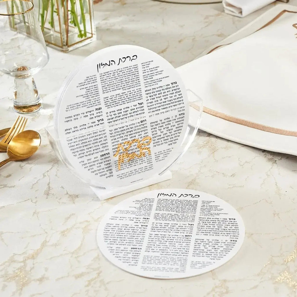 White round bencher set displayed on marble table with place settings and gold accents for Shabbat and holiday entertaining.