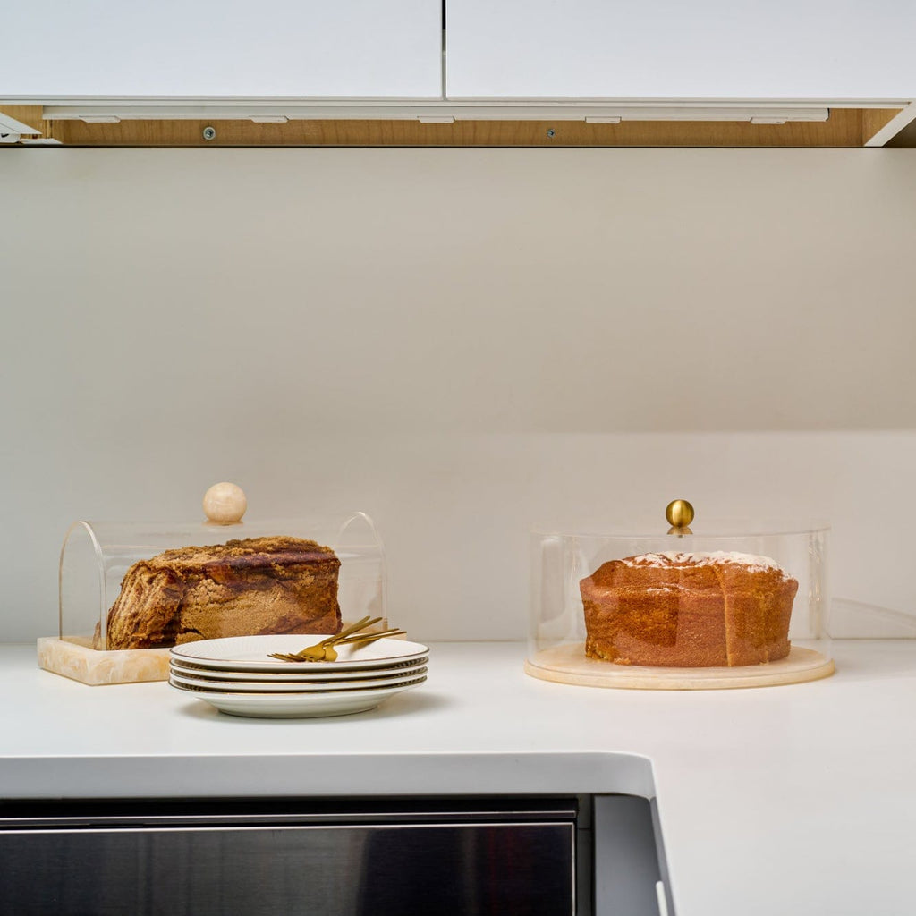 Round Resin Cake Dome crafted with a crystal-clear acrylic lid and elegant gold accent knob, set on a smooth marbled cream resin base.