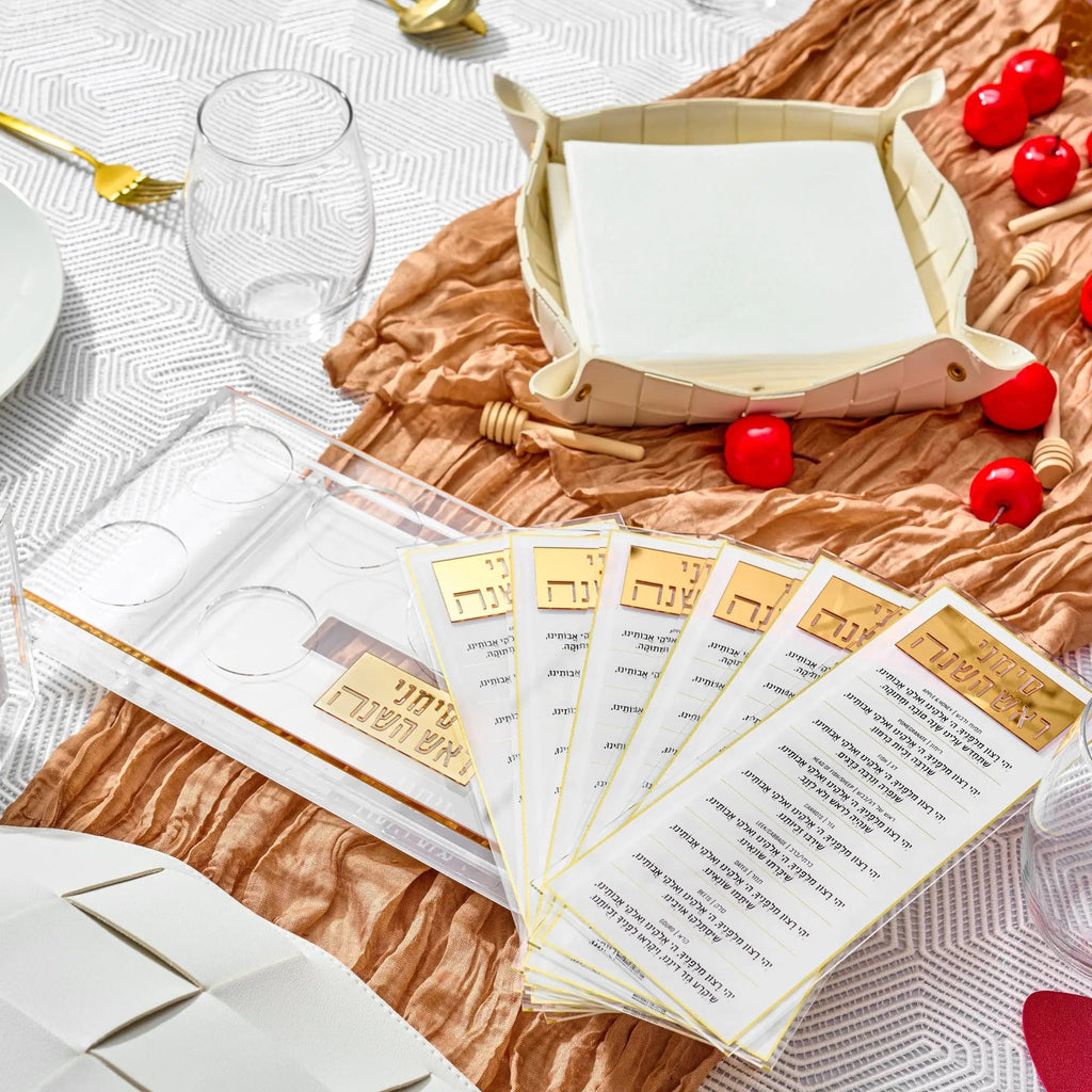 Waterdale Collection suspended simanim tray card set displayed on woven placemat with holiday table setting and fresh produce.
