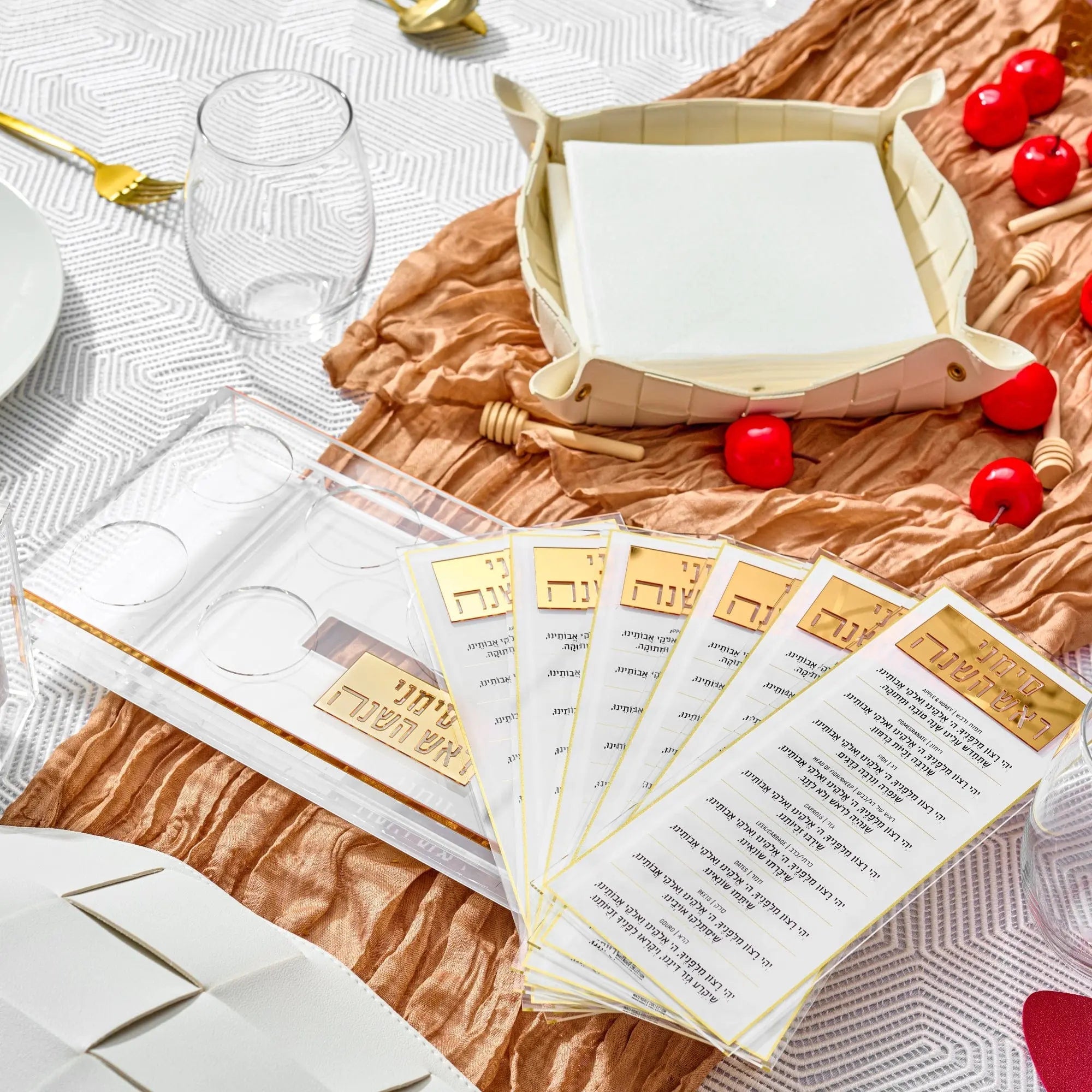Waterdale Collection suspended simanim tray card set displayed on woven placemat with holiday table setting and fresh produce.