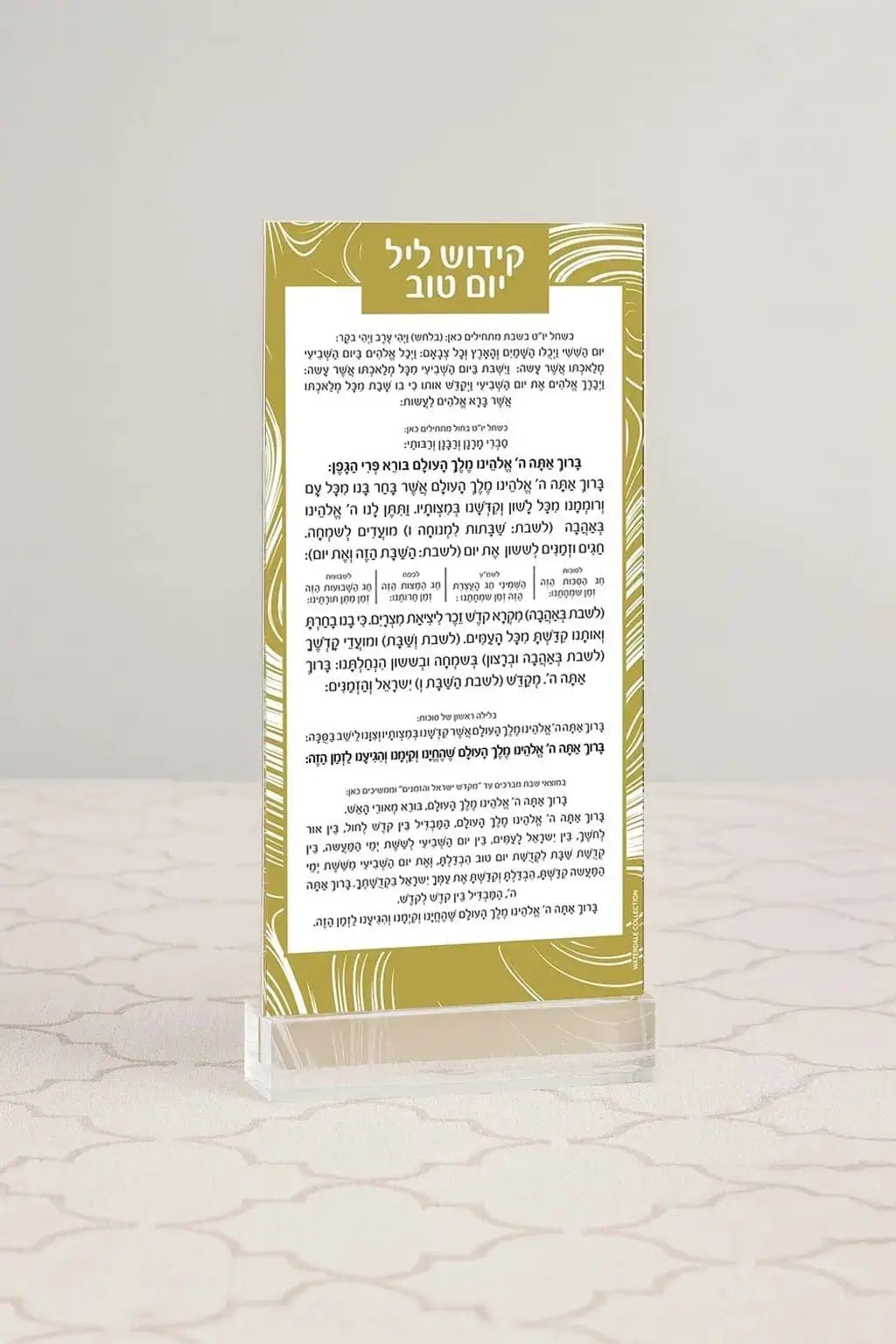 Gold swirl Kiddush Yom Tov card in clear lucite stand displaying Hebrew text for holiday blessings.