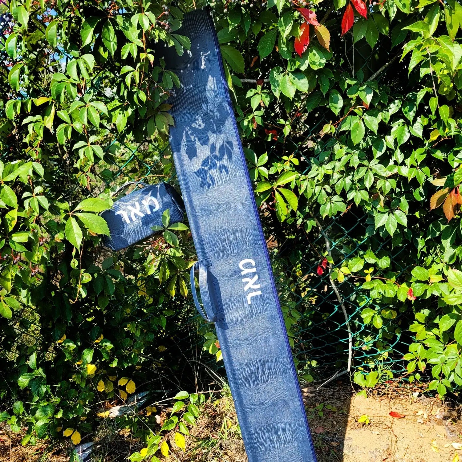 Navy blue textured leather esrog bag hanging outdoors, showing material quality and classic design for Sukkot holiday use.