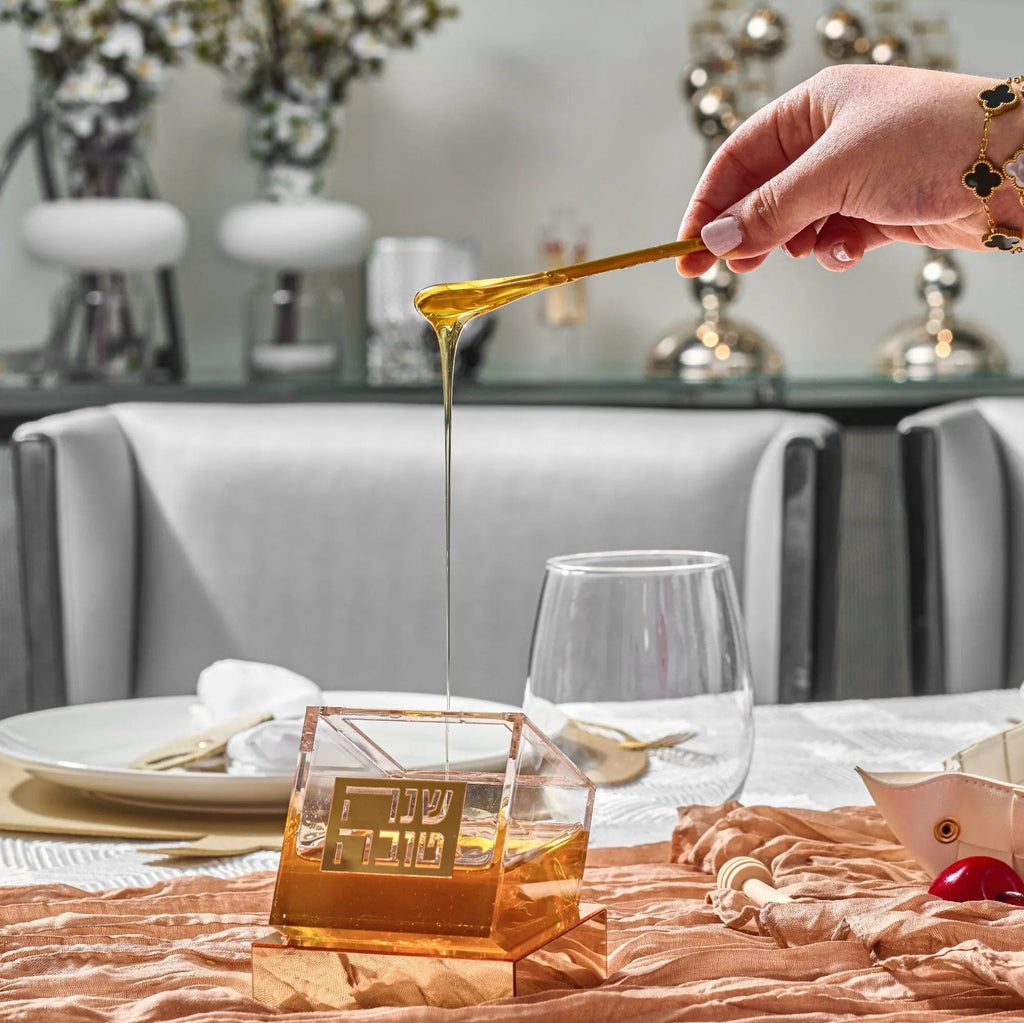 Gold-toned tilt honey dish from Waterdale Collection displayed on a formal dining table with place settings and decorative elements.