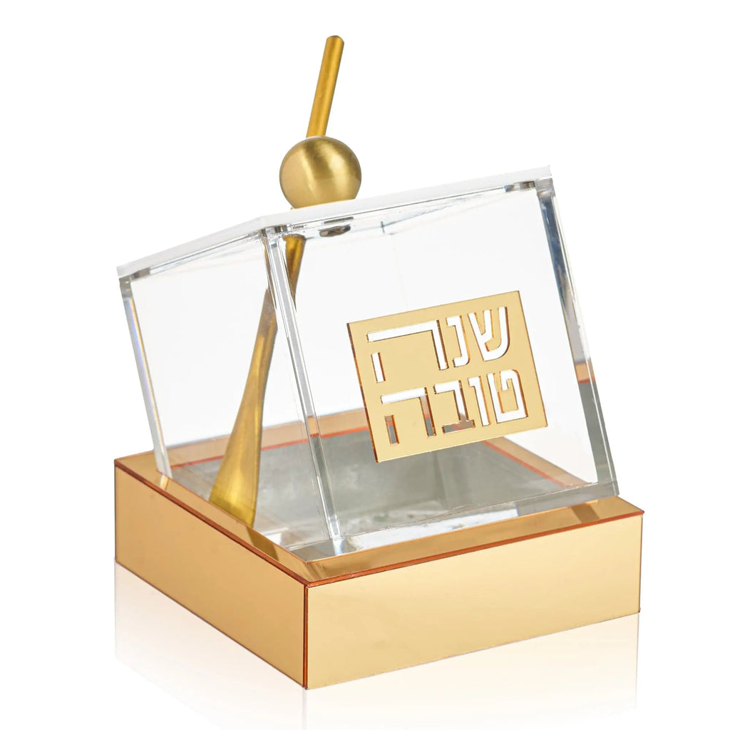 Tilt honey dish by Waterdale Collection with glass container, brass spoon, and gold-toned base on white background.