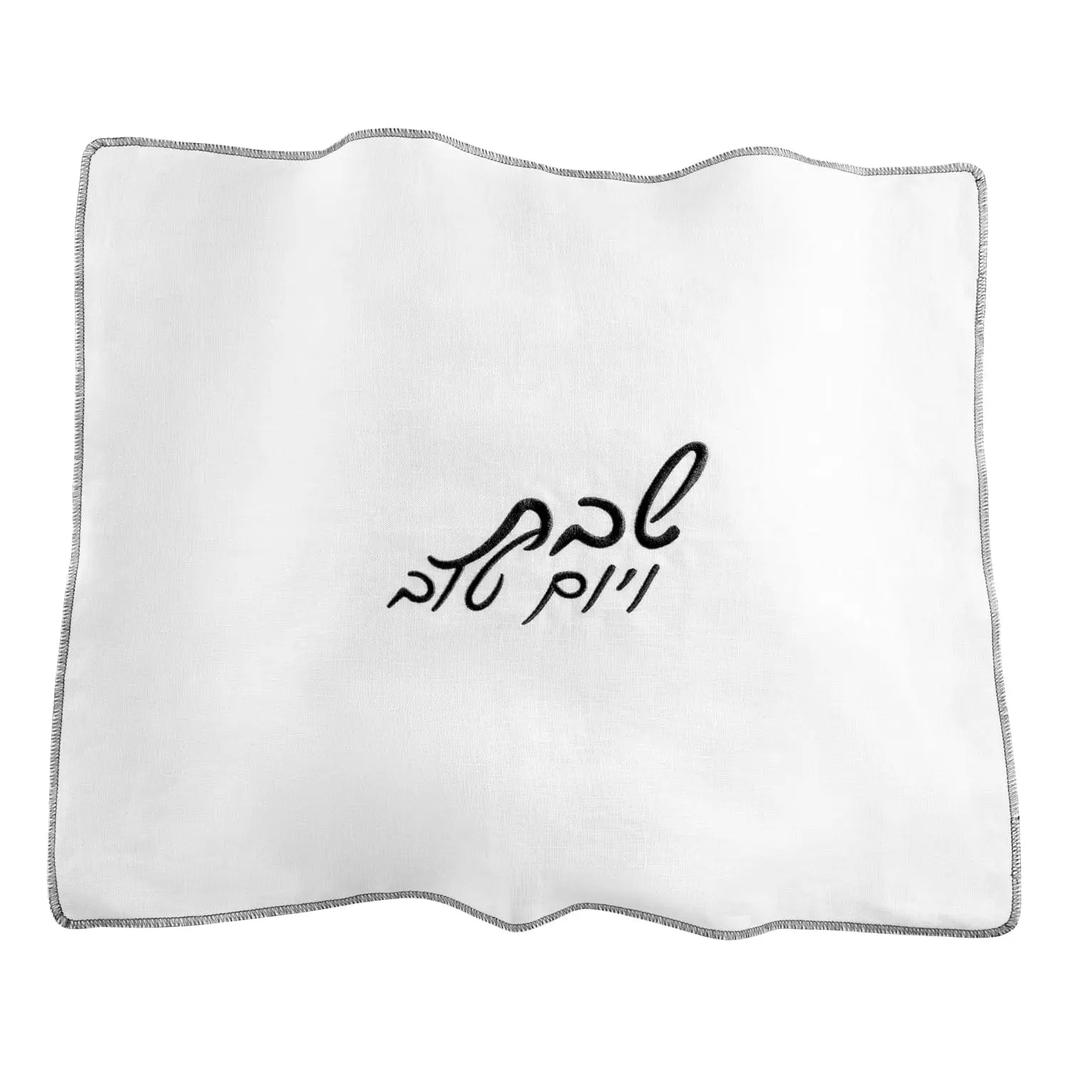 White linen challah cover with black embroidered Hebrew text, featuring a wavy border design for Shabbat dining.