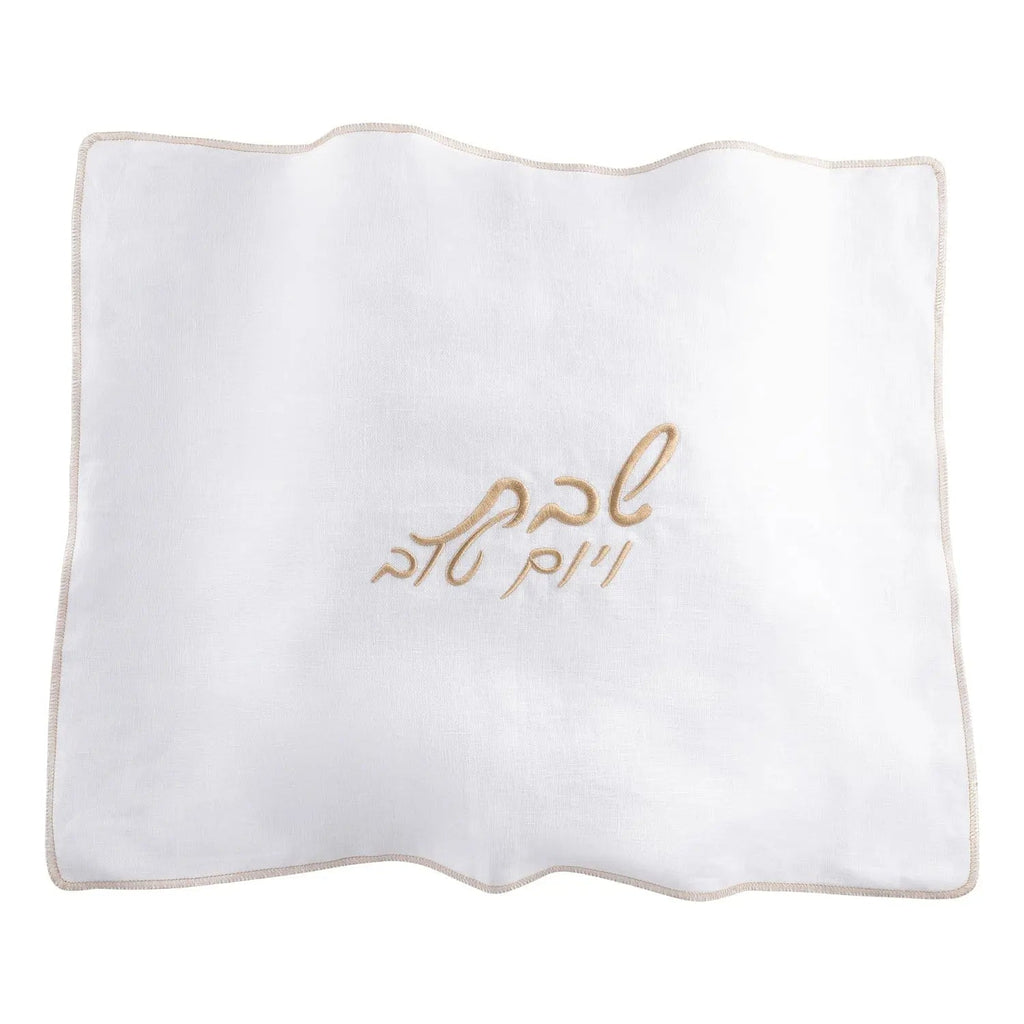 White linen challah cover with delicate embroidered Hebrew text, perfect for Shabbat table settings.